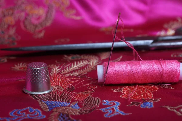 ピンク糸のスプールとシンブルオンヴィンテージピンクサテン — ストック写真