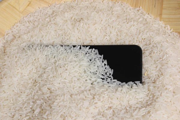 Smartphone Schüssel Mit Weißem Reis Wasser Und Feuchtigkeit Vom Handy lizenzfreie Stockfotos