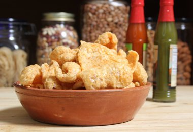 Fried Pork Rinds With Hot Sauce in Rustic Kitchen