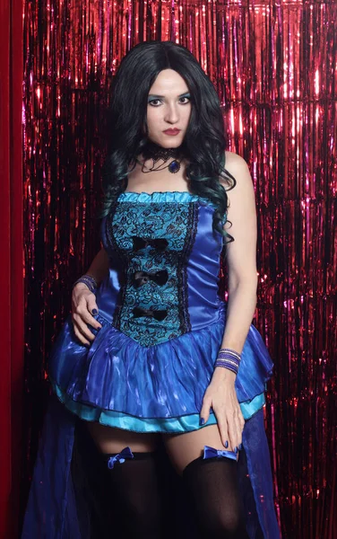 Woman Preforming Burlesque on Stage. Blue Satin Corset Costume With Red Background