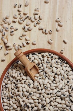 Tahta masadaki kasede pişmemiş siyah göz bezelyeleri.