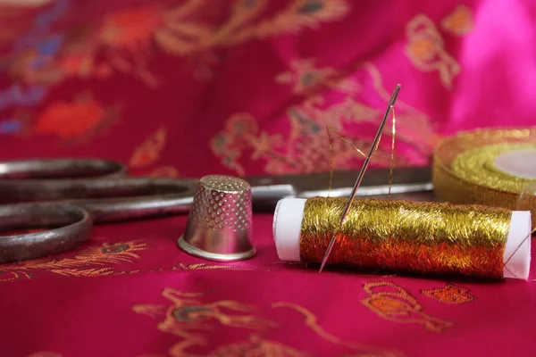 复古粉红丝织物上的金金属丝丝线和镶嵌片 — 图库照片