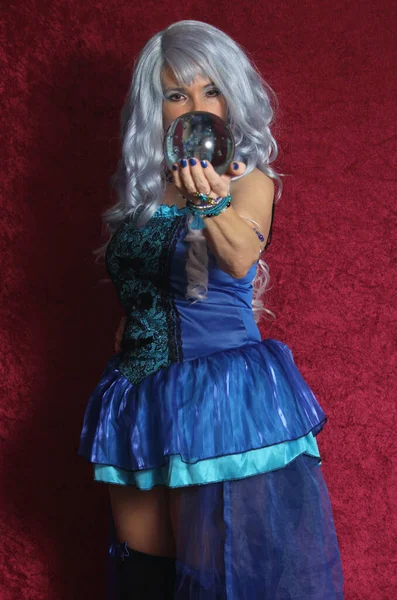 Γυναίκα Ντυμένη Σαν Μπλε Μάγισσα Κρατώντας Κρυστάλλινη Σφαίρα Στο Κόκκινο — Φωτογραφία Αρχείου