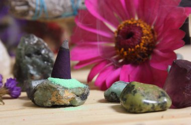 Incense Cone on Stone Slab With Chakra Crystals and Flowers