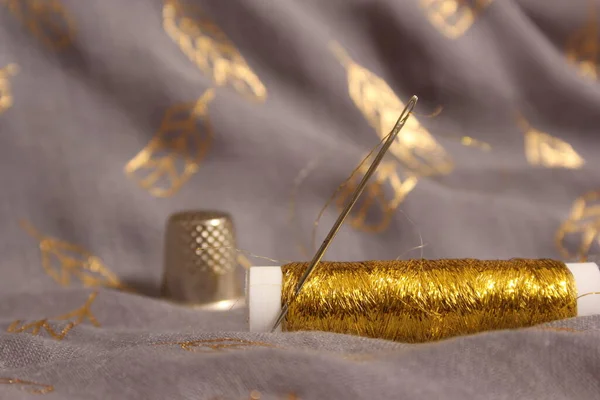 Spule Aus Metallischem Goldfaden Auf Grauem Und Goldenem Chiffongewebe — Stockfoto