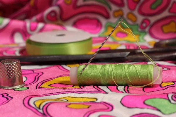 古色粉和绿色织物上的绿色螺纹 顶针和针片 — 图库照片