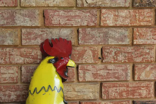 Metal Rooster on Brick Wall. Rural East Texas