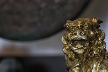 Altın Asyalı Aslan heykeli Arka planda Gong Sığ DOF