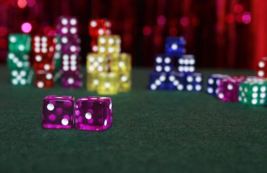 Pembe Bokeh Arkaplanlı Yeşil Keçe Üzerine Renkli Zar Yığını