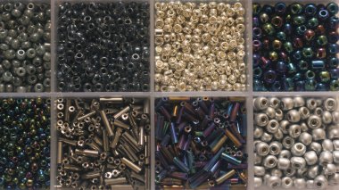 Mücevher yapmak için konteynırda siyah ve gri boncuklar