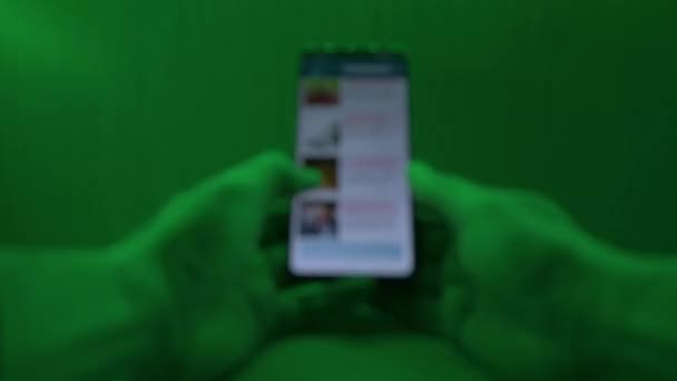 静态软焦距画面显示一只手握着智能手机 带着彩灯闪烁的滚动 — 图库视频影像