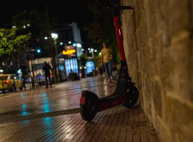 Atina, Yunanistan-4 Ekim 2024 fotoğrafında kaldırıma park etmiş bir elektrikli scooter görülüyor. Seçici odak, gece fotoğrafçılığı-şehir hayatı.