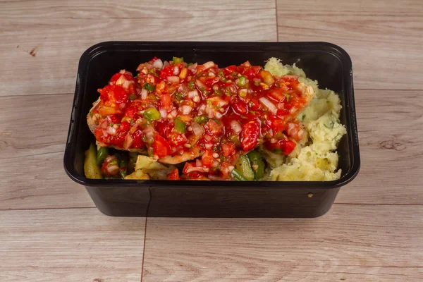 veg salad in black container on wooden background