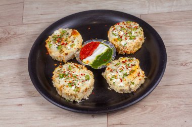 Tahta arka planda yeşil otlu peynirli sarımsaklı ekmek.