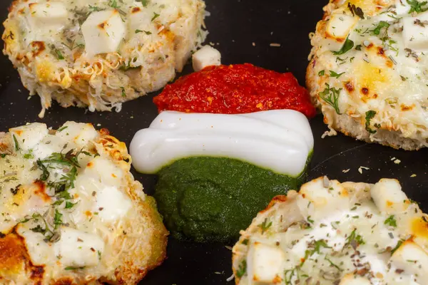 Dört peynirli sarımsaklı ekmek arasında portakal, beyaz ve yeşil sos veya chatani. tiranga kavramı.