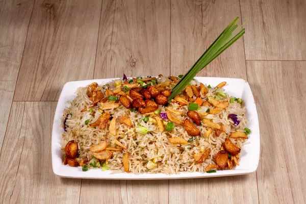 Beyaz seramik tabakta yanmış sarımsaklı sebzeli pilav yakın..