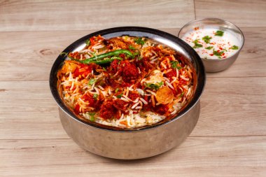 Geleneksel sebzeli biryani karışık sebzelerle karışık raita ile servis edilir.