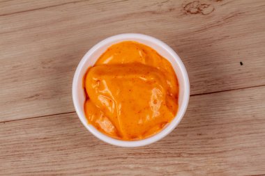 Ahşap arka planda beyaz kase lezzetli chipotle sosu.