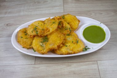 İzole edilmiş Havza Pakora, tahta arka planda patates pakoda denilen popüler Hint sokak yemekleri.