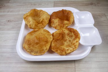 Plain Puri served in a plate. It's an Indian deep-fried bread made from whole-wheat flour, popular main course or breakfast recipe clipart