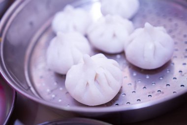 Modak 'ın Maharashtrian tatlısı, arka planda Ghee kasesi ve Lord Ganpati ile süslenmek üzere Tanrı Ganesh' e sunuluyor..