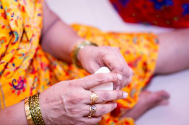 Woman making sweet rice modak stuffed with grated coconut and jaggery clipart