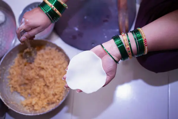 Hindistancevizi rendelenmiş pirinçli modak yapan bir kadın.