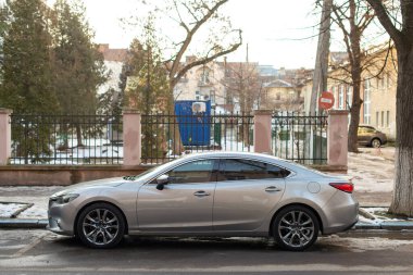 Ivano-Frankivsk, Ukrayna - 19 Ocak 2024: Mazda Atenza (Mazda Atenza) orta boy sedan üçüncü nesil, yan görüş. Sokakta araba park etmek..