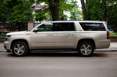 Ivano-Frankivsk, Ukrayna - 12 Haziran 2024: Chevrolet Suburban, Chevrolet 11 nesil yan görüş tarafından üretilen bir SUV serisidir. Sokakta araba park etmek.