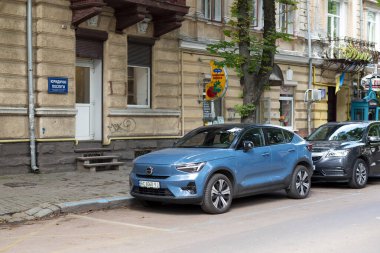 Ivano-Frankivsk, Ukrayna - 09 Aug 2024: Blue Volvo EC40 (XC40) Pure Electric Volvo 'nun ilk batarya elektrikli modelidir ve lüks SUV yan görüşüdür. Sokakta araba park etmek.