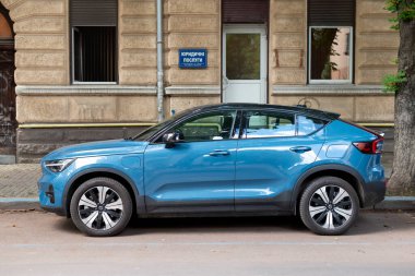 Ivano-Frankivsk, Ukrayna - 09 Aug 2024: Blue Volvo EC40 (XC40) Pure Electric Volvo 'nun ilk batarya elektrikli modelidir ve lüks SUV yan görüşüdür. Sokakta araba park etmek.