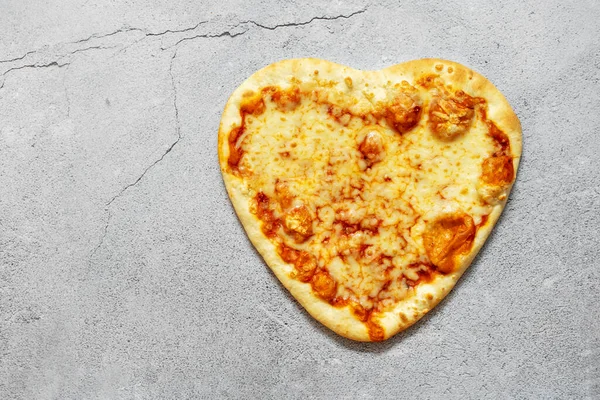 Pizza heart shaped on background . Concept of romantic love for Valentines Day . . High quality photo