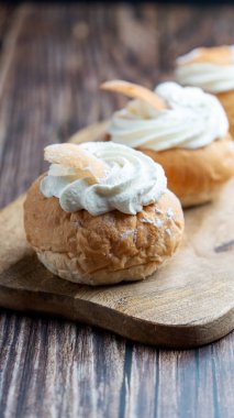 Semla, fastelavnsbolle, fastlagsbulle. Decorated with an Estonian flag. On a wooden table with a dark background. High quality photo
