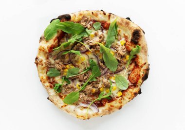 Ton balıklı pizza, soğan, mısır, kurutulmuş fesleğen ve beyaz arka planda izole edilmiş roka. Pizza üstü manzaralı. Yüksek kaliteli fotoğraf.