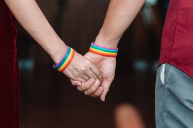 lgbbt çifti veya lgbtqia + çifti bileklerine gökkuşağı renkli bileklikler takar ve kendilerini aşkta ve cinsiyette özgürce ifade edebilen lgbtqia + grubunu sembolize etmek için el ele tutuşurlar..