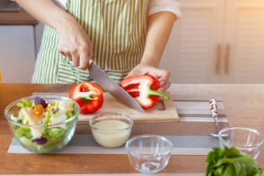 A young woman prepares bell peppers for her breakfast and is ready for a healthy meal on the table with healthy, organic vegetables on the table. healthy food preparation ideas