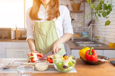 A young woman prepares bell peppers for her breakfast and is ready for a healthy meal on the table with healthy, organic vegetables on the table. healthy food preparation ideas