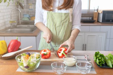 young woman preparing bell Pepper as a breakfast ingredient and ready for healthy cooking and on the table there are vegetables that are healthy organic ingredients. healthy food preparation ideas
