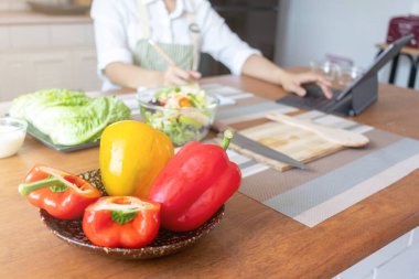 young woman preparing bell Pepper as a breakfast ingredient and ready for healthy cooking and on the table there are vegetables that are healthy organic ingredients. healthy food preparation ideas