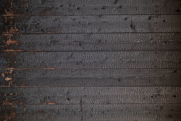 The black wood wall background caused by burning the wood to become carbonized and has a black surface that looks natural is used as a decorative wall to make the building look unusual.