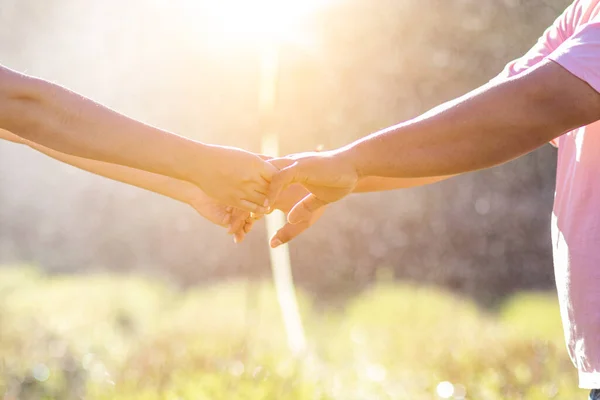 male and female couple holding hands to show friendship, love and concern because holding hands is a symbol of couple love. Male and female couple express their love by holding hands.
