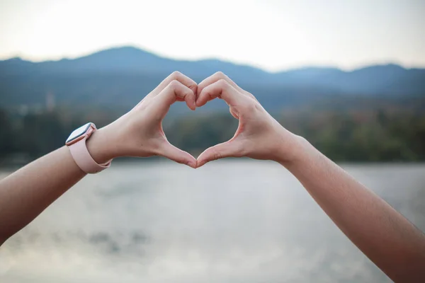 male and female couple showing their hands up to form heart symbol to show friendship love and kindness because heart is symbol of love. male and female couple showing their love with heart symbol