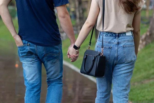 male and female couple holding hands to show friendship, love and concern because holding hands is a symbol of couple love. Male and female couple express their love by holding hands.
