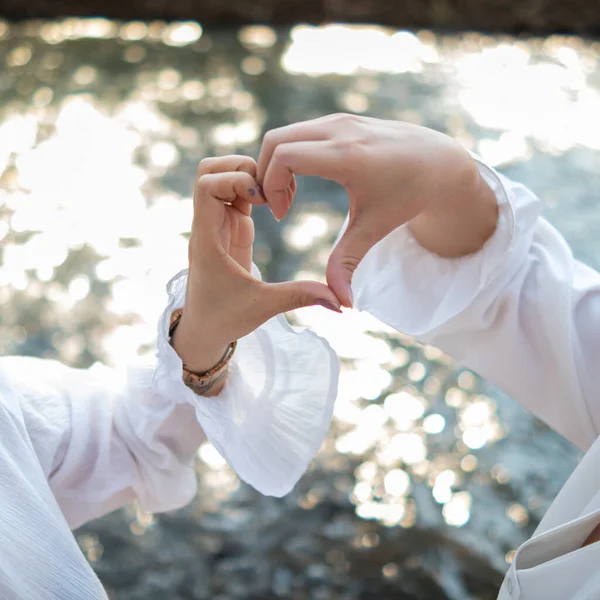 male and female couple showing their hands up to form heart symbol to show friendship love and kindness because heart is symbol of love. male and female couple showing their love with heart symbol