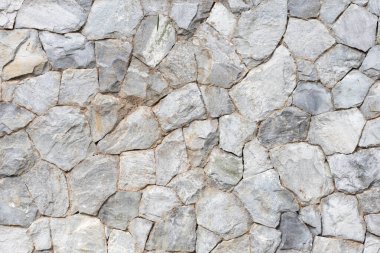 Doğal taşlardan inşa edilen ve güzel, güçlü ve doğal bir yüzeye sahip olmak için düzenlenmiş olan taş duvar arka planı, taş duvarı insanlar arasında popüler kılıyor. arkaplan ve kopyalama alanı
