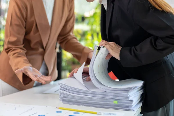 stock image Businesswoman hands working on stacks of paper documents to search and review documents piled on table before sending them to board of directors to use  correct documents in meeting with Businessman