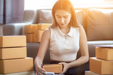 Küçük bir girişimci, gelen siparişleri müşterilere ulaştırmak üzere nakliye şirketine götürmek üzere ürünleri paket kutularına koyuyor. Concept Etrade Team çevrimiçi satışları