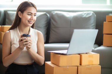 Küçük bir girişimci, gelen siparişleri müşterilere ulaştırmak üzere nakliye şirketine götürmek üzere ürünleri paket kutularına koyuyor. Concept Etrade Team çevrimiçi satışları