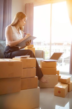 Küçük bir girişimci, gelen siparişleri müşterilere ulaştırmak üzere nakliye şirketine götürmek üzere ürünleri paket kutularına koyuyor. Concept Etrade Team çevrimiçi satışları