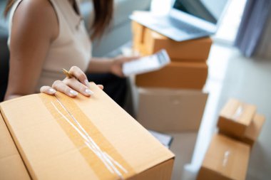 Küçük bir girişimci, gelen siparişleri müşterilere ulaştırmak üzere nakliye şirketine götürmek üzere ürünleri paket kutularına koyuyor. Concept Etrade Team çevrimiçi satışları